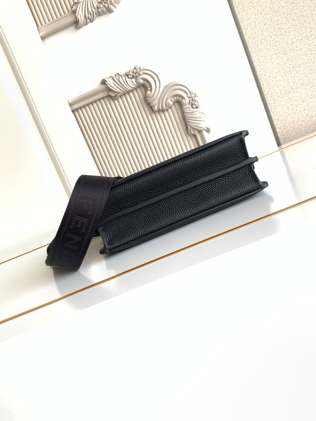 Black pebbled leather flap bag with shoulder strap