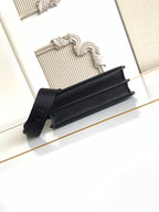 Black pebbled leather flap bag with shoulder strap