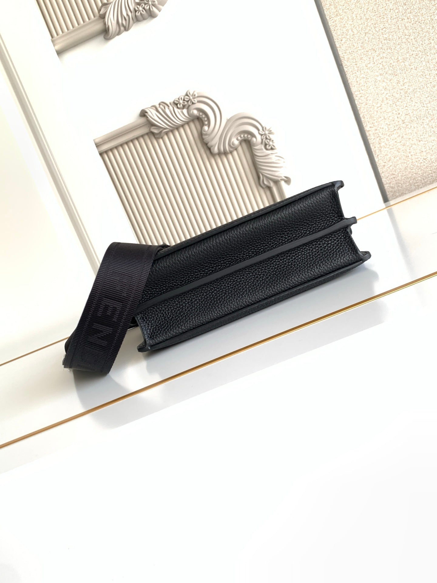 Black pebbled leather flap bag with shoulder strap