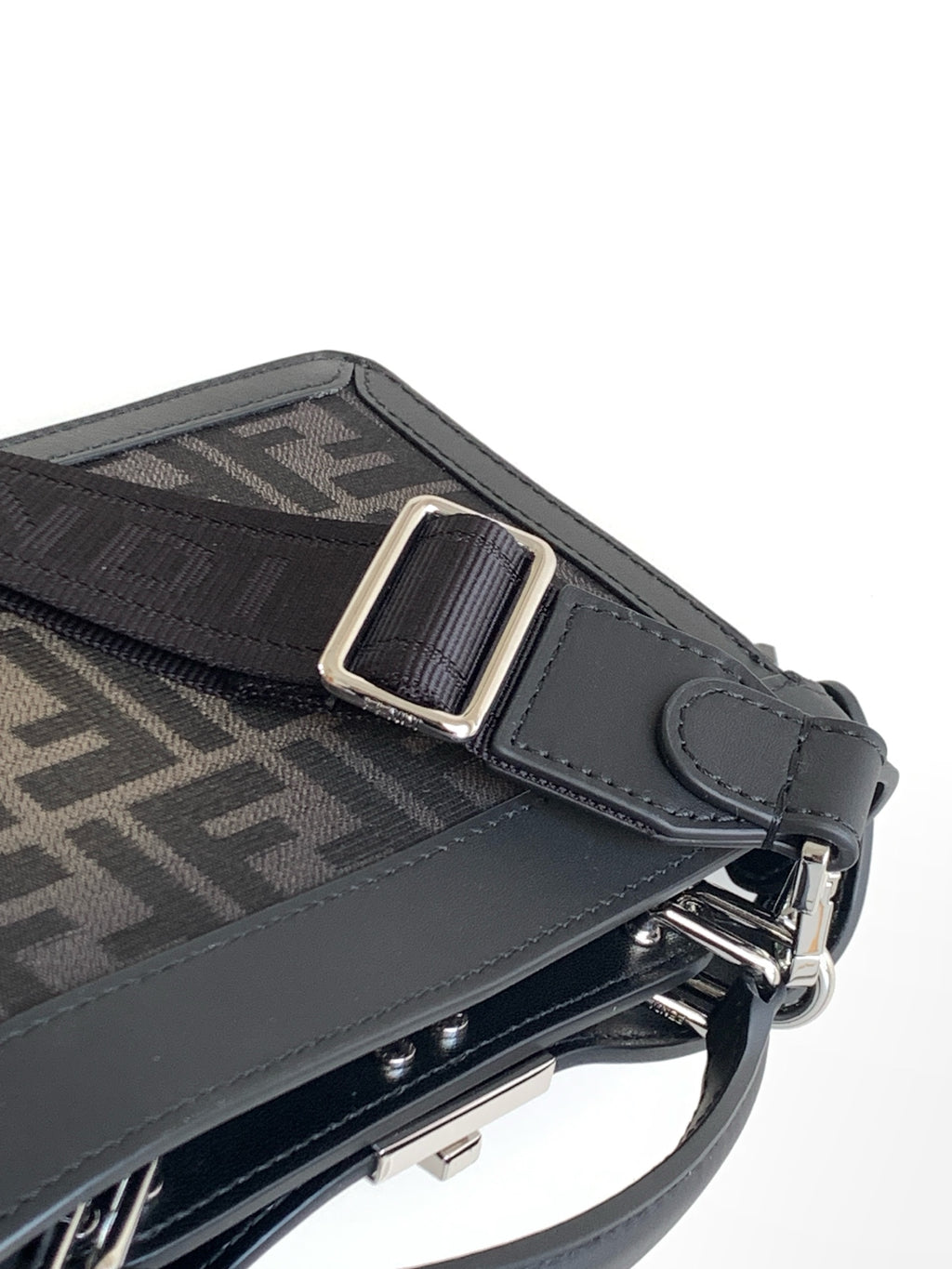 Black Fendi bag strap detail with metal buckle, D-ring, and textured panel