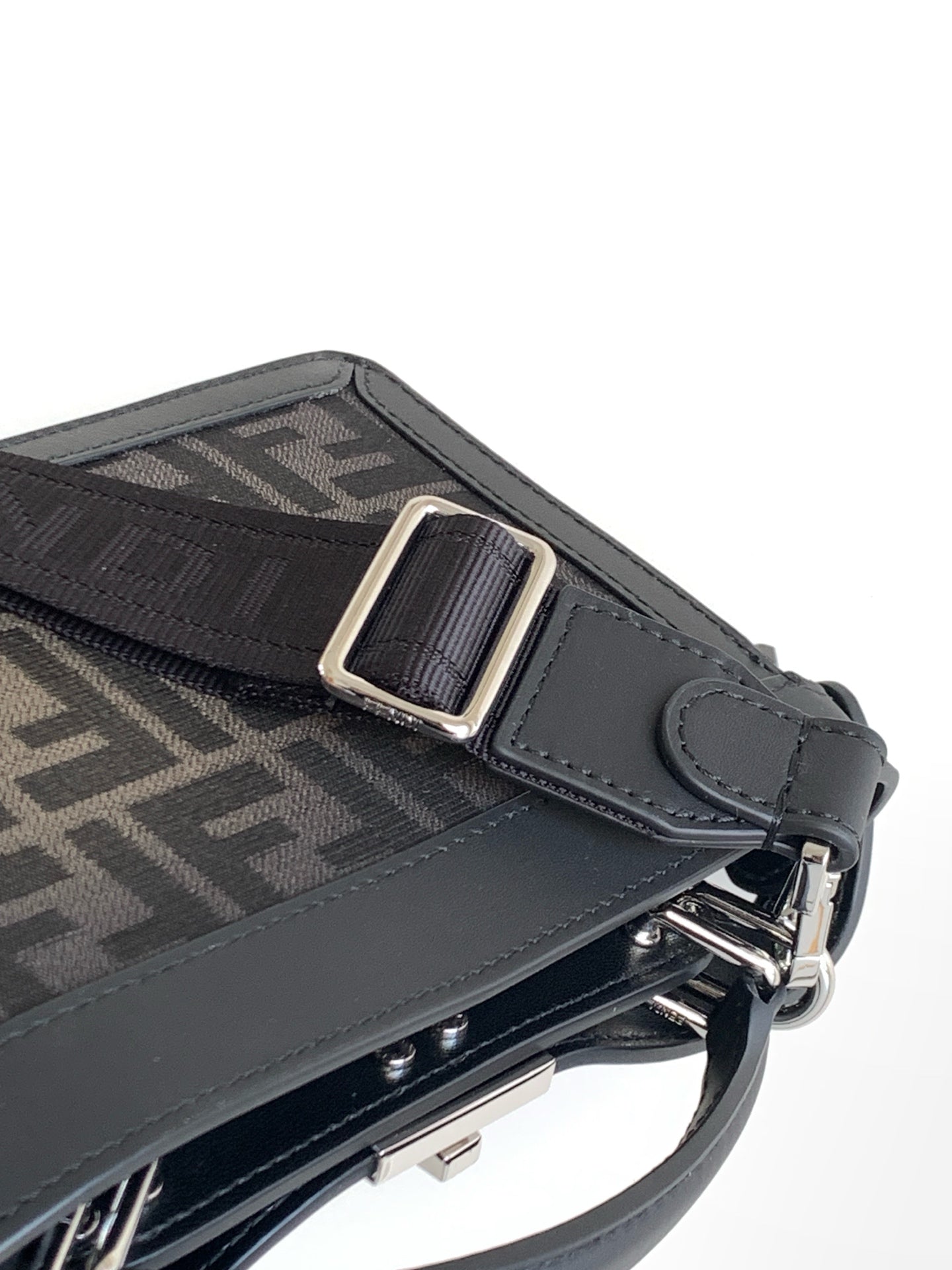 Black Fendi bag strap detail with metal buckle, D-ring, and textured panel