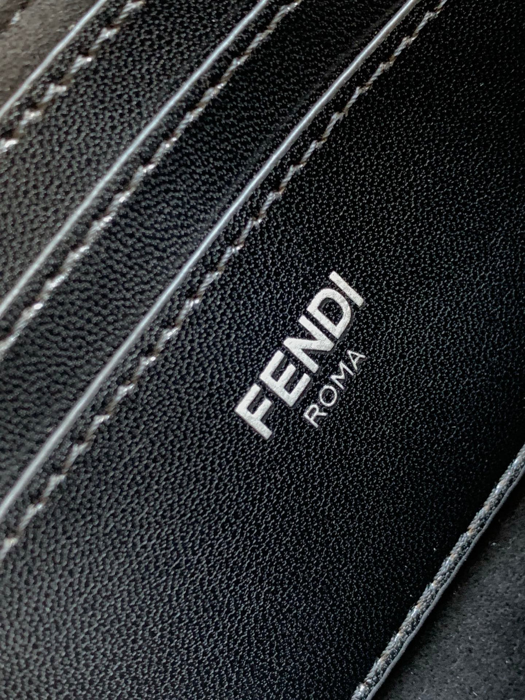 Fendi ROMA logo on black textured bag panel with contrast stitching