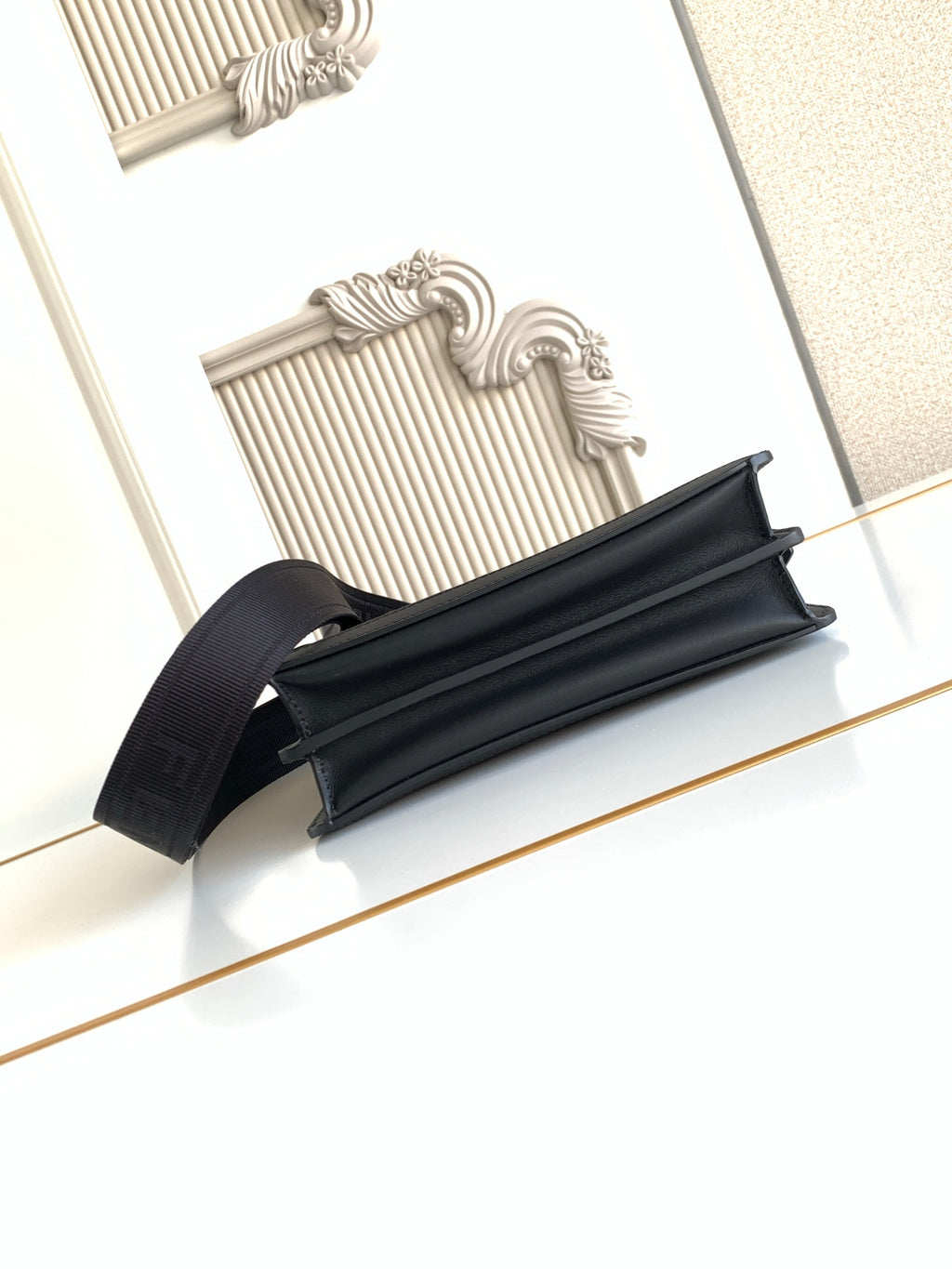 Black Fendi baguette-style bag with wide strap and top zipper