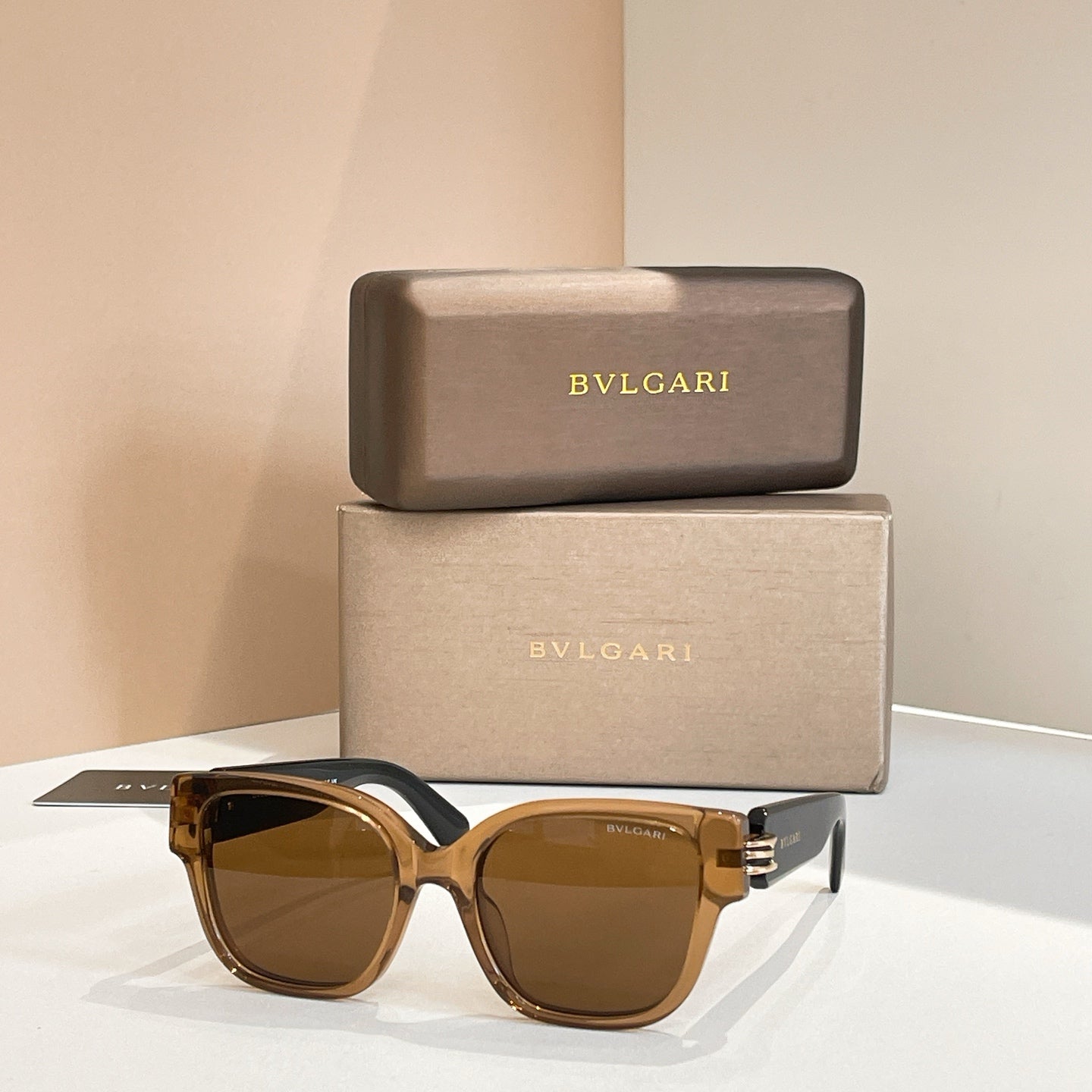 Amber sunglasses with tortoiseshell frames and gold-tone metal hinge detail.