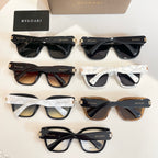 Assorted sunglasses display with black, tan, and white frames and dark tinted lenses.