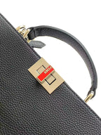 Black leather Fendi strap with gold square logo buckle, close-up