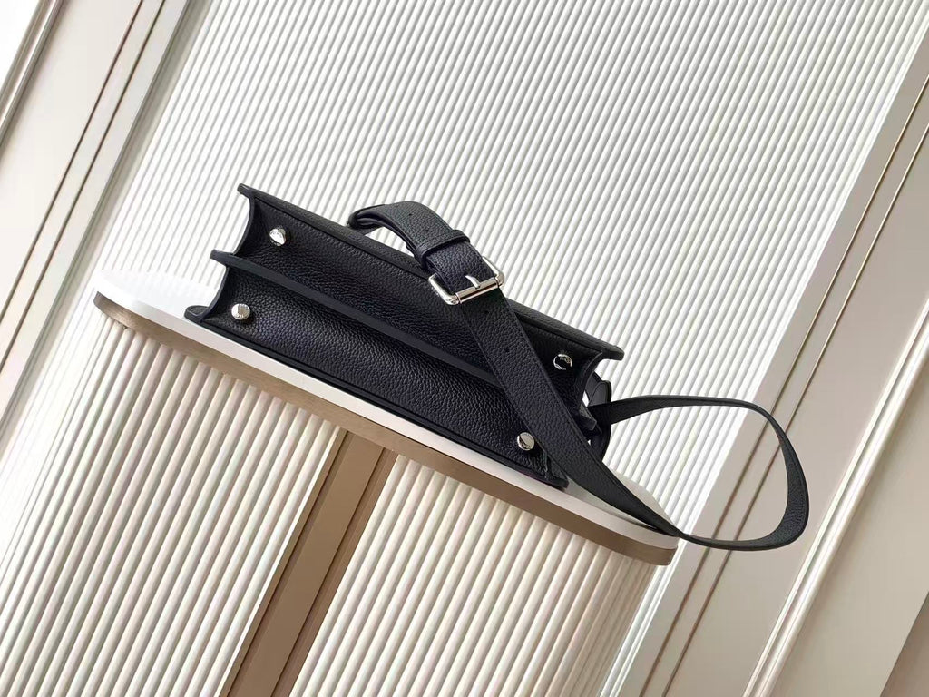 Black leather Fendi handbag with top clasp handle and shoulder strap, side view