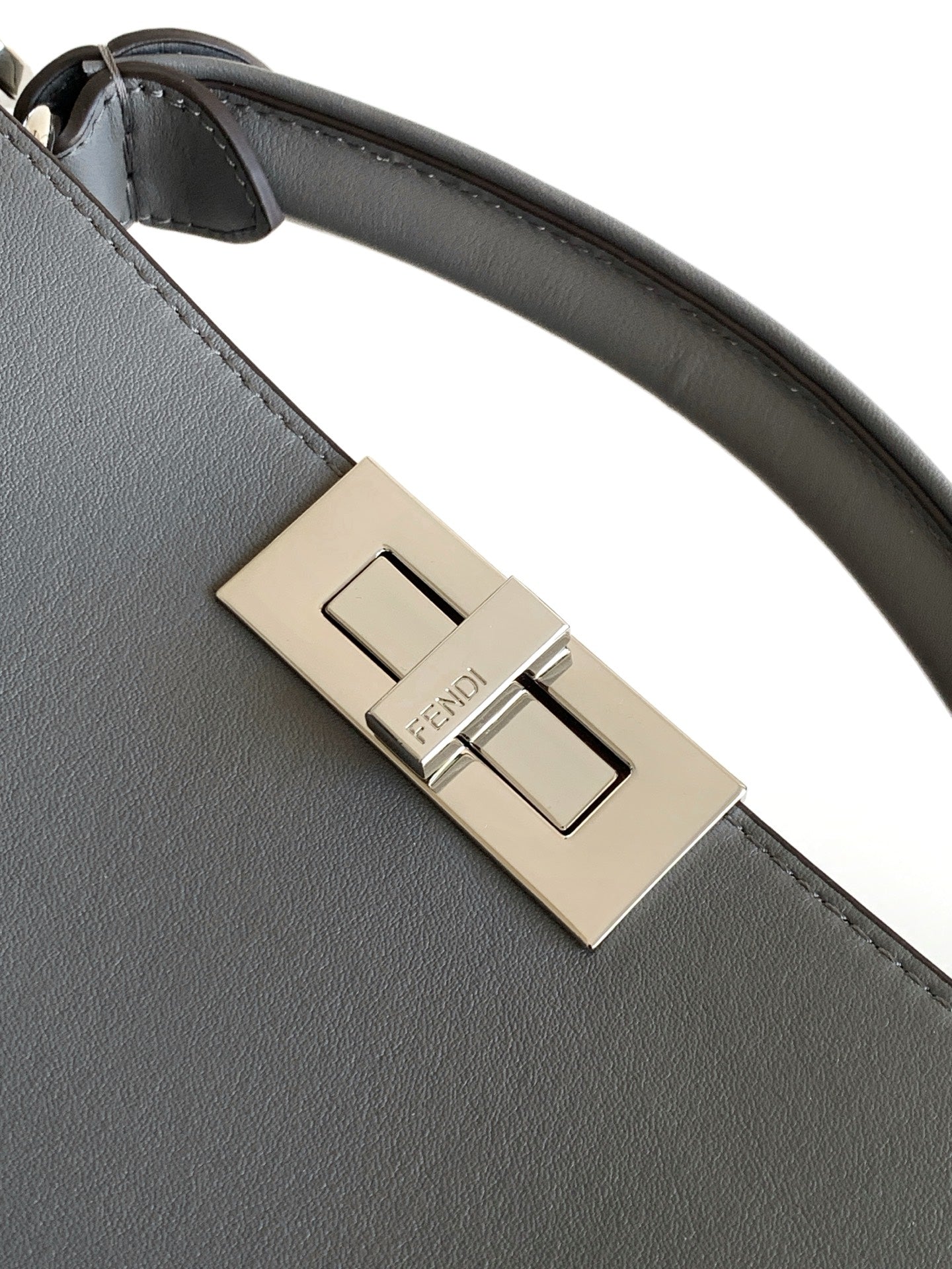Fendi bag buckle hardware with gold-tone clasp on gray leather strap