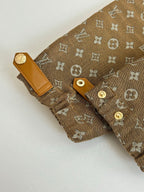 Louis Vuitton monogram jacket cuff detail with tan leather tabs and gold buttons