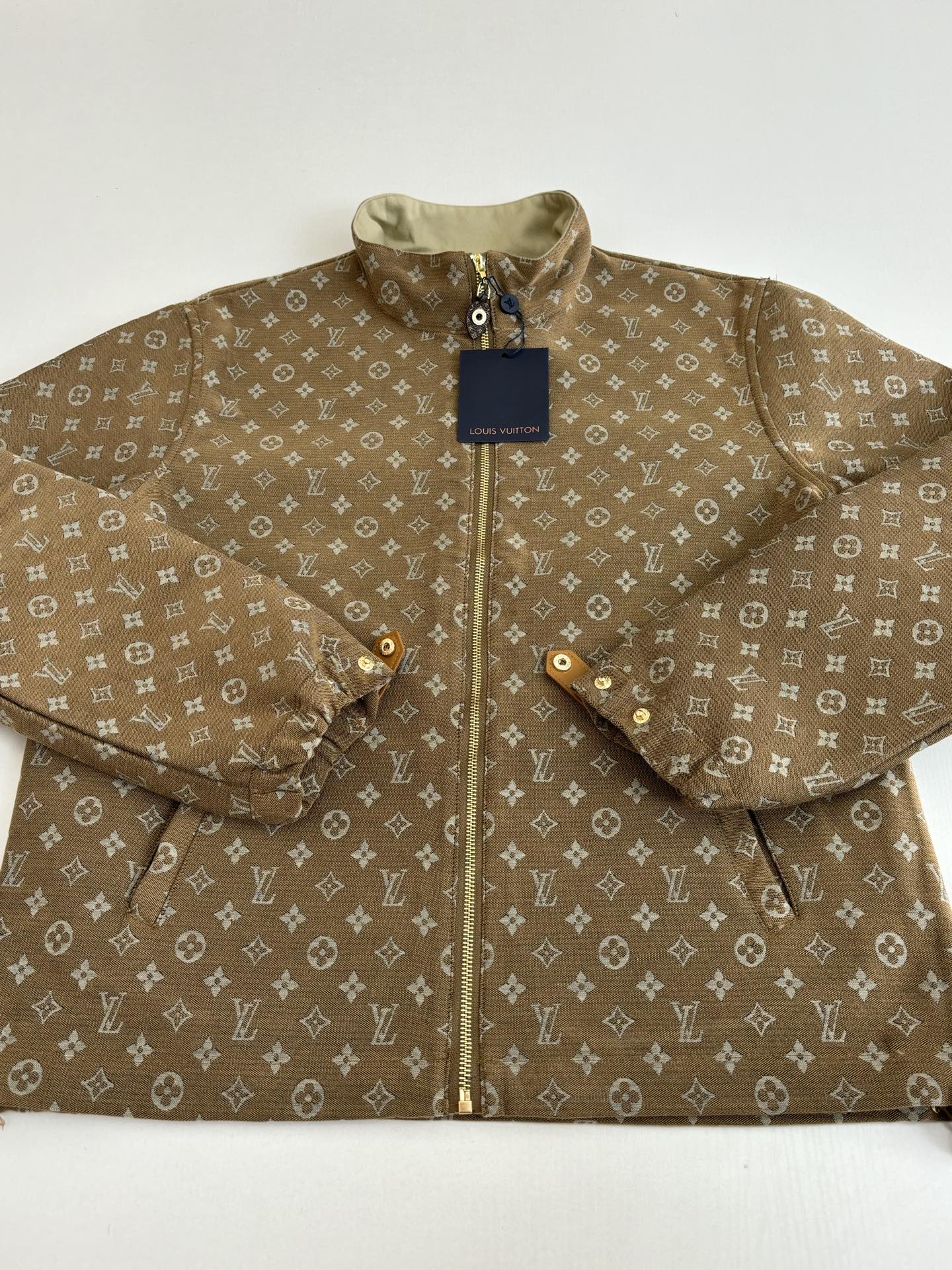 Louis Vuitton monogram jacket close-up, brown fabric with front zipper and collar
