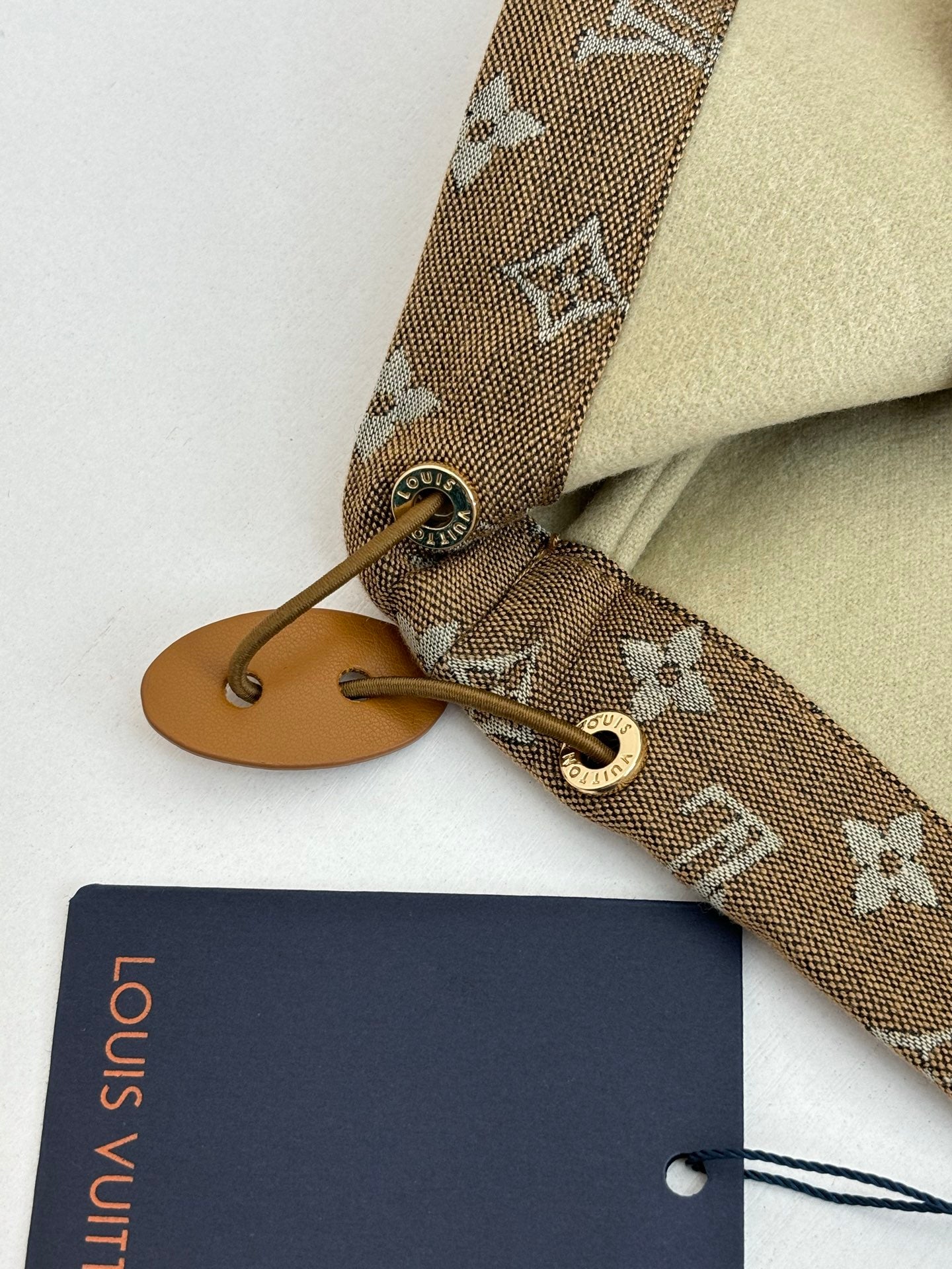 Louis Vuitton hood tie and monogram cuff close-up with tan leather end piece