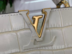 Louis Vuitton V logo on white croc-embossed flap, gold-tone emblem