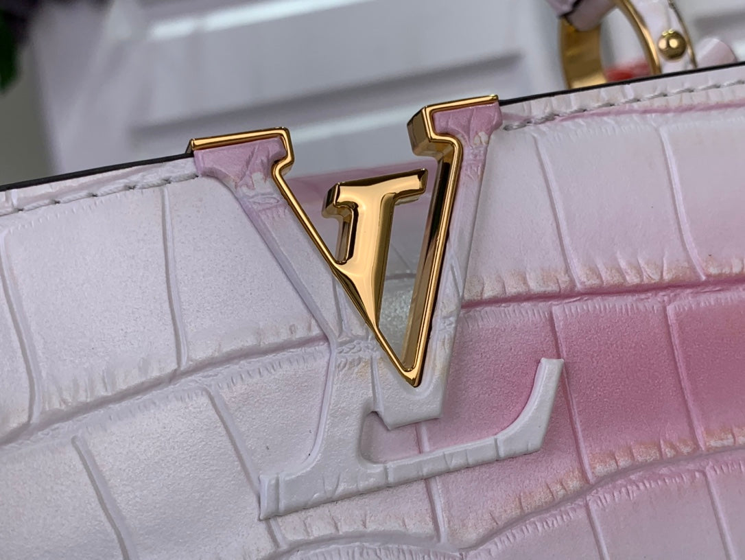 Louis Vuitton LV gold emblem on pink ombre croc-embossed leather bag.