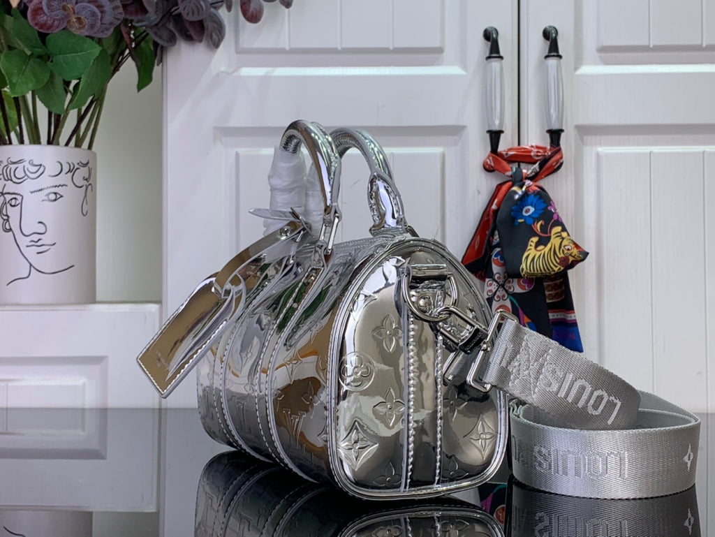 Silver Louis Vuitton handbag with double handles and attached shoulder strap