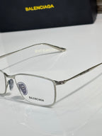 Balenciaga eyeglasses close-up with silver metal frame and clear lenses.
