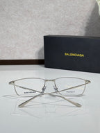 Balenciaga eyeglasses with clear lenses and silver metal frames on display.