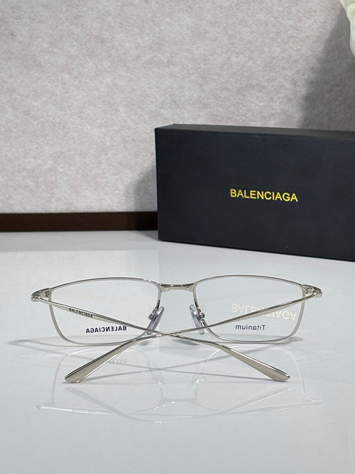 Balenciaga eyeglasses with clear lenses and silver metal frames on display.