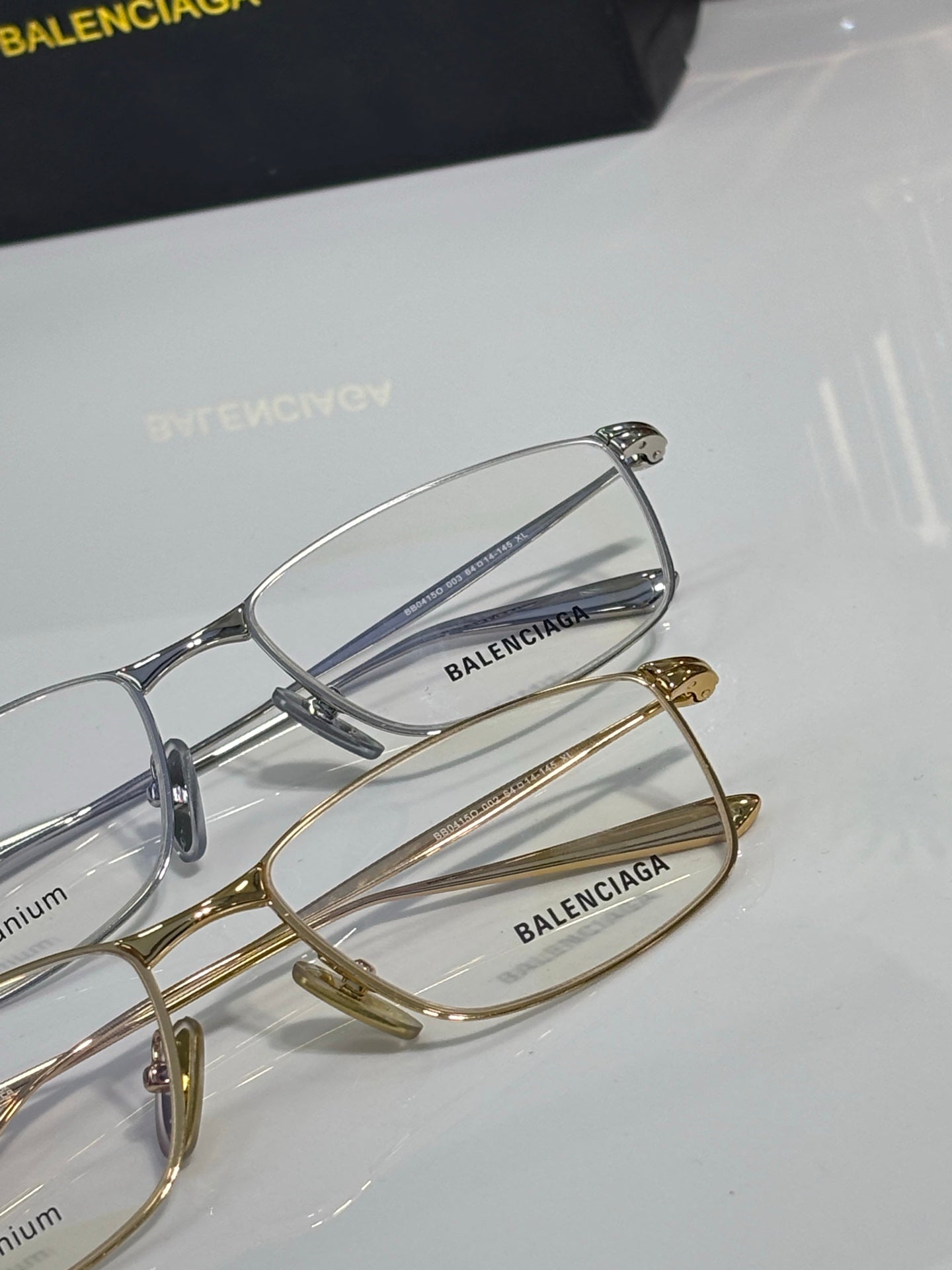 Balenciaga eyeglasses pair with silver and gold metal frames, clear lenses.