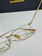Balenciaga eyeglasses close-up with gold metal frame and tinted lens center.