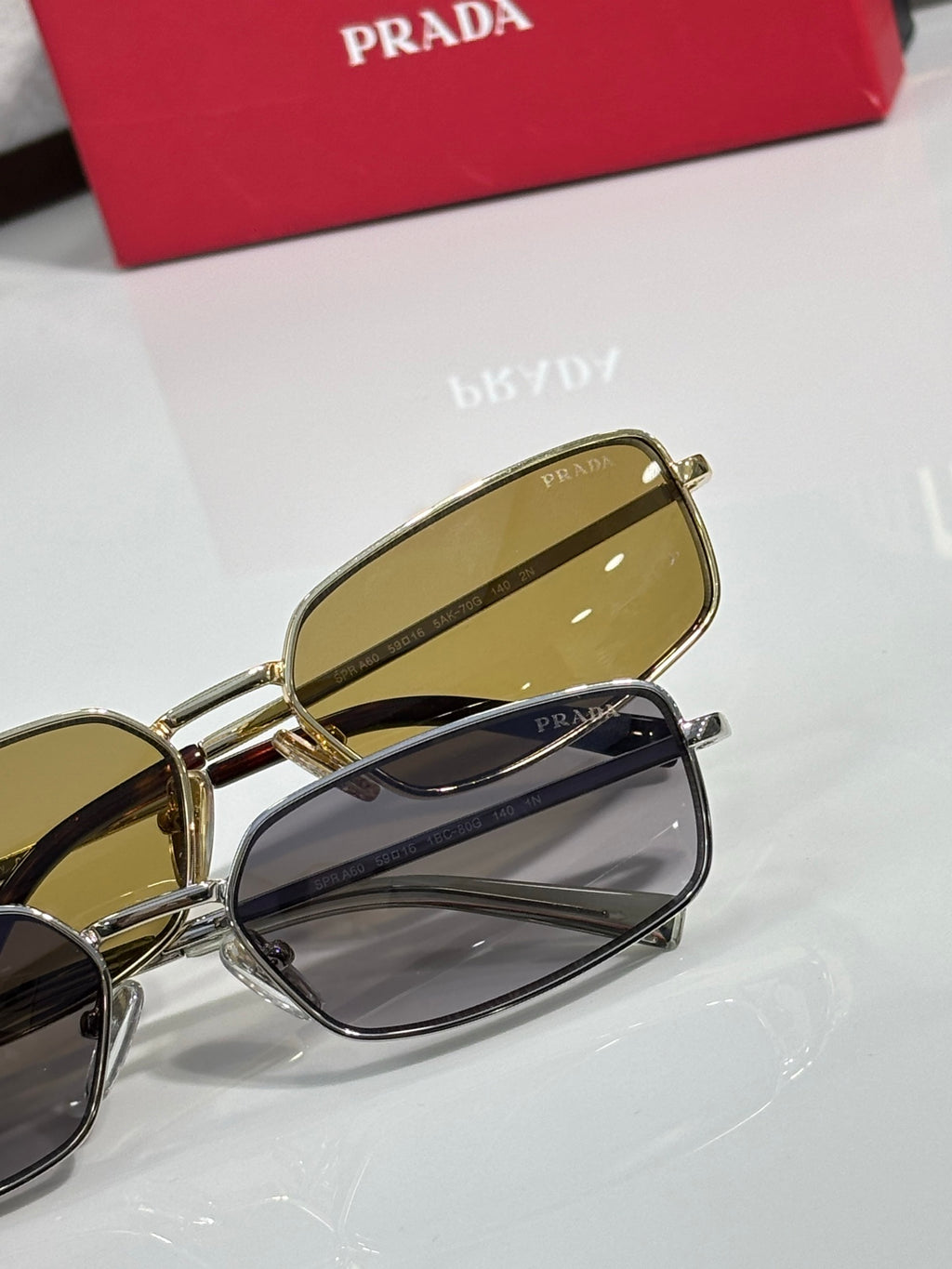 Sunglasses close-up: gold frame yellow lenses with dark lens pair behind