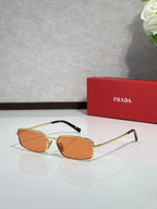Sunglasses with gold-tone frame and orange-tinted lenses