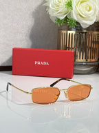 Sunglasses with gold-tone frame and brown-orange tinted lenses