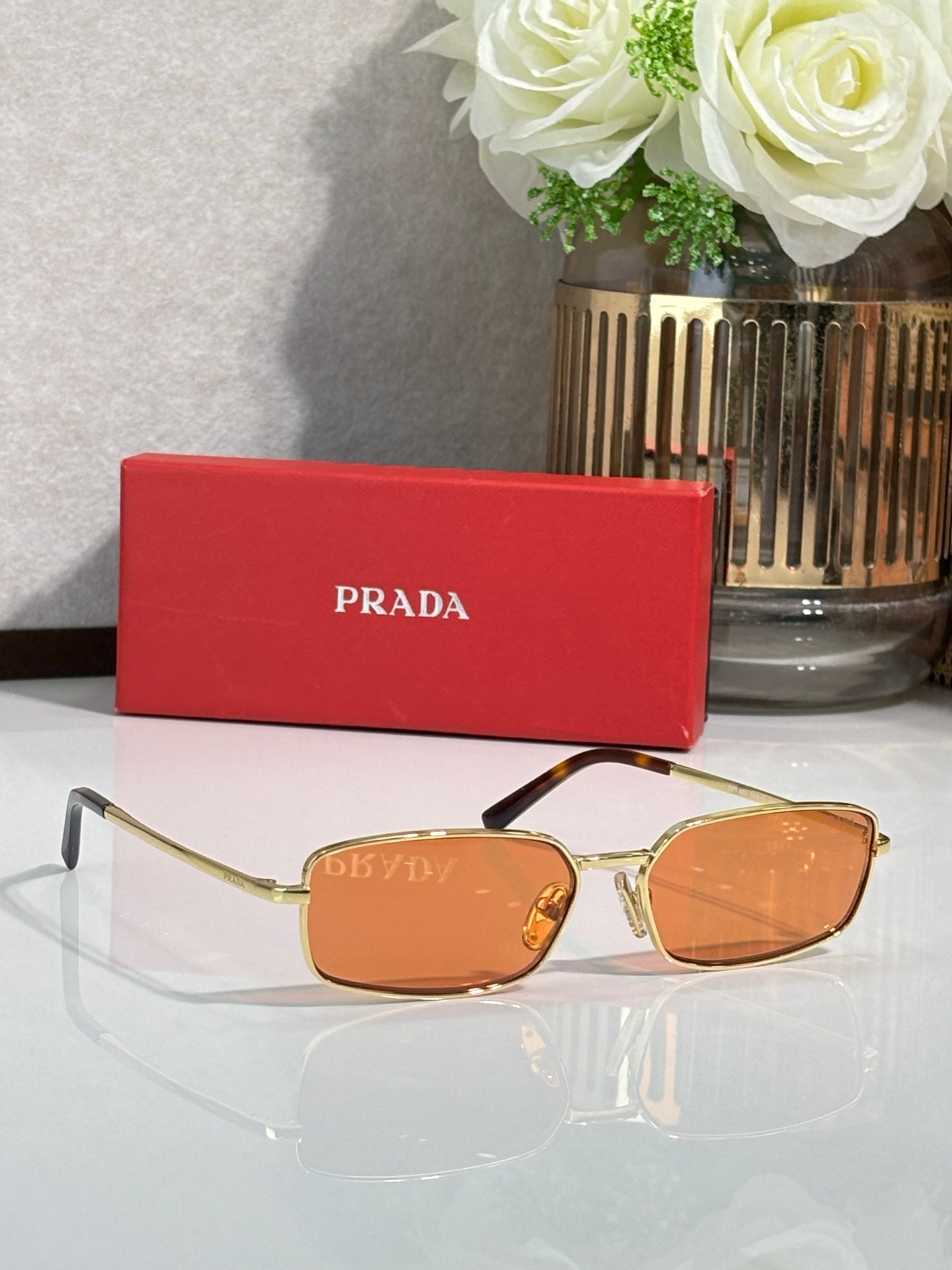 Sunglasses with gold-tone frame and brown-orange tinted lenses