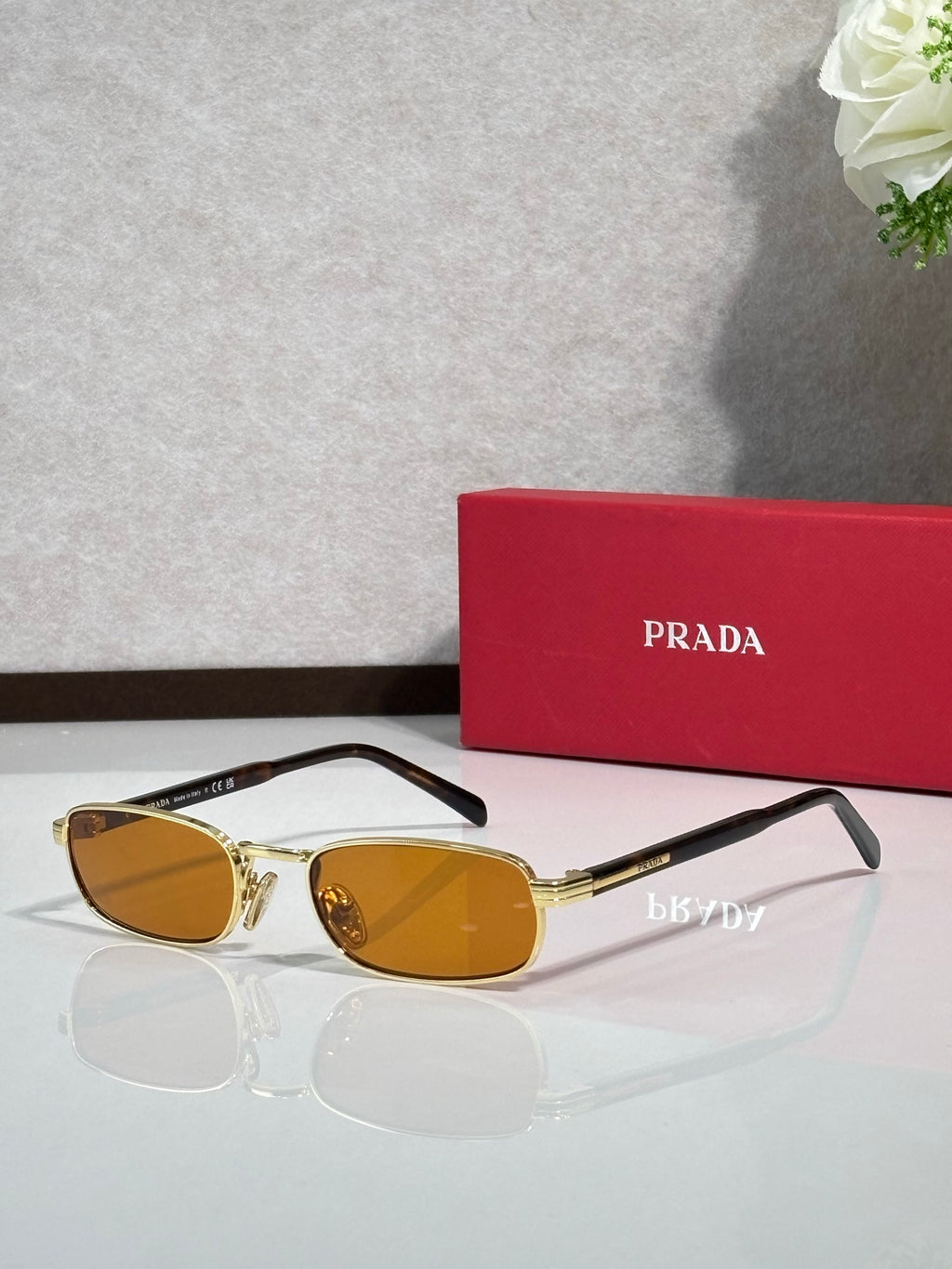 Prada sunglasses with gold frame, tortoise arms, amber oval lenses