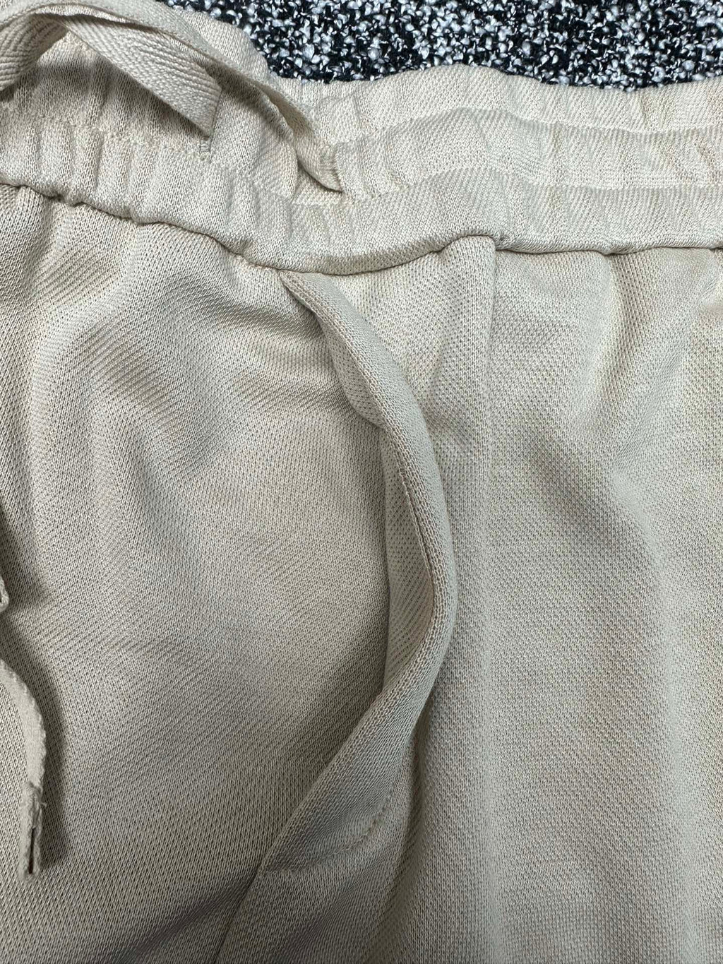 Cream pants close-up of elastic waistband and drawstring cord