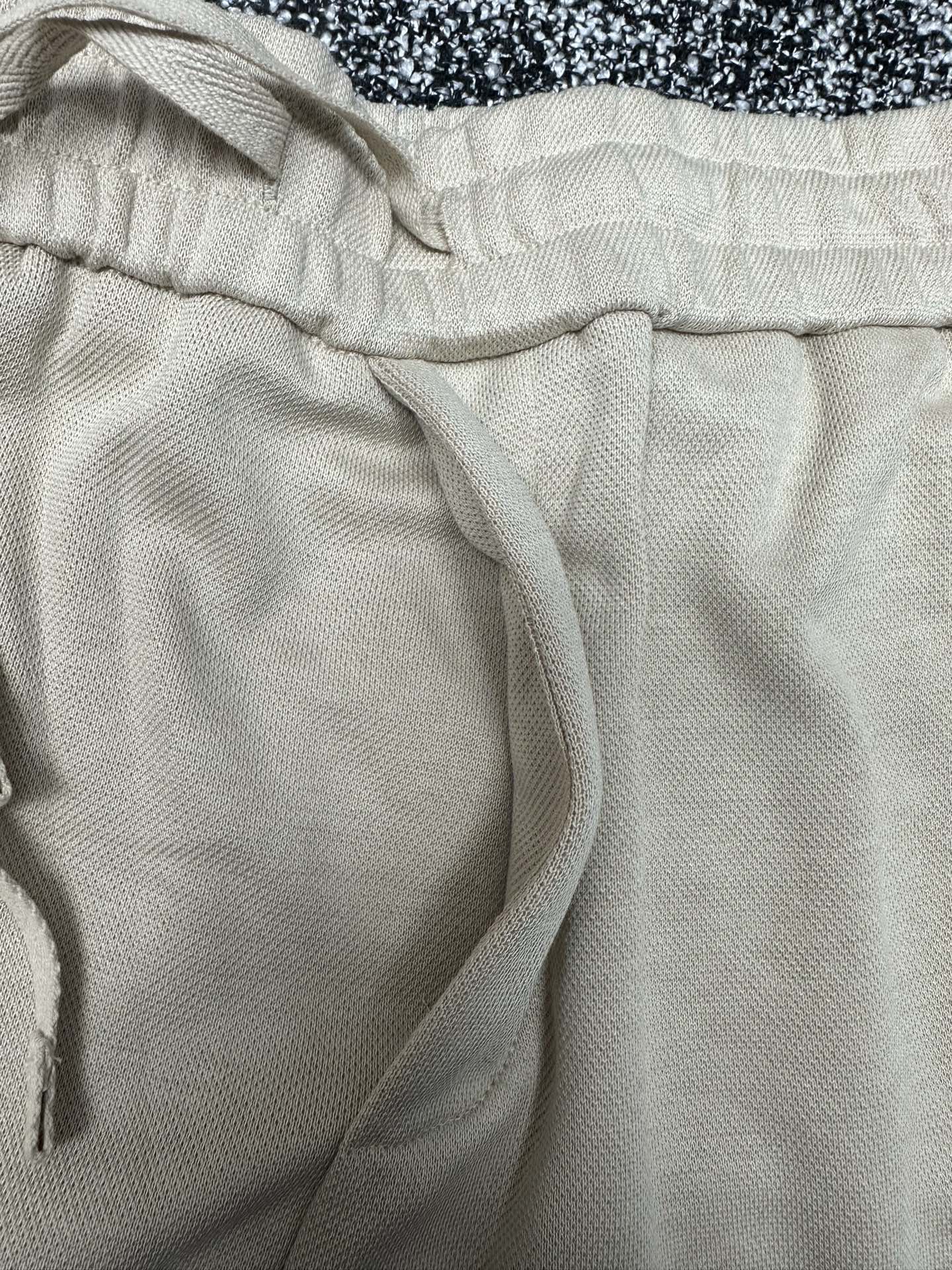 Cream pants close-up of elastic waistband and drawstring cord