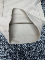 Cream pants close-up of pocket opening and waistband seam