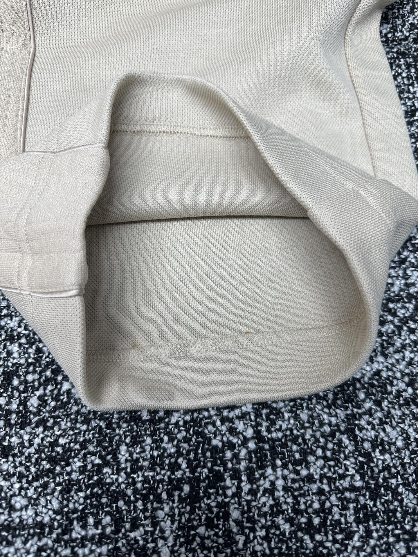 Cream pants close-up of pocket opening and waistband seam