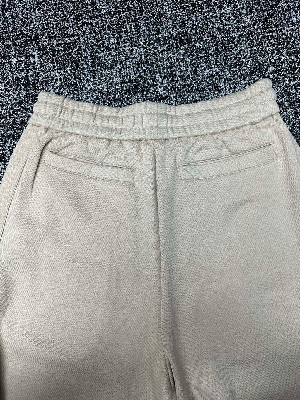 Cream wide-leg pants with elastic waistband and front pocket openings
