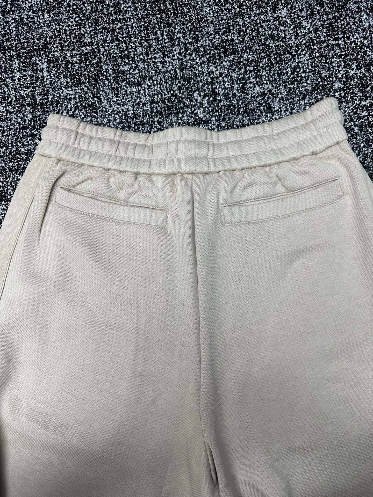 Cream wide-leg pants with elastic waistband and front pocket openings