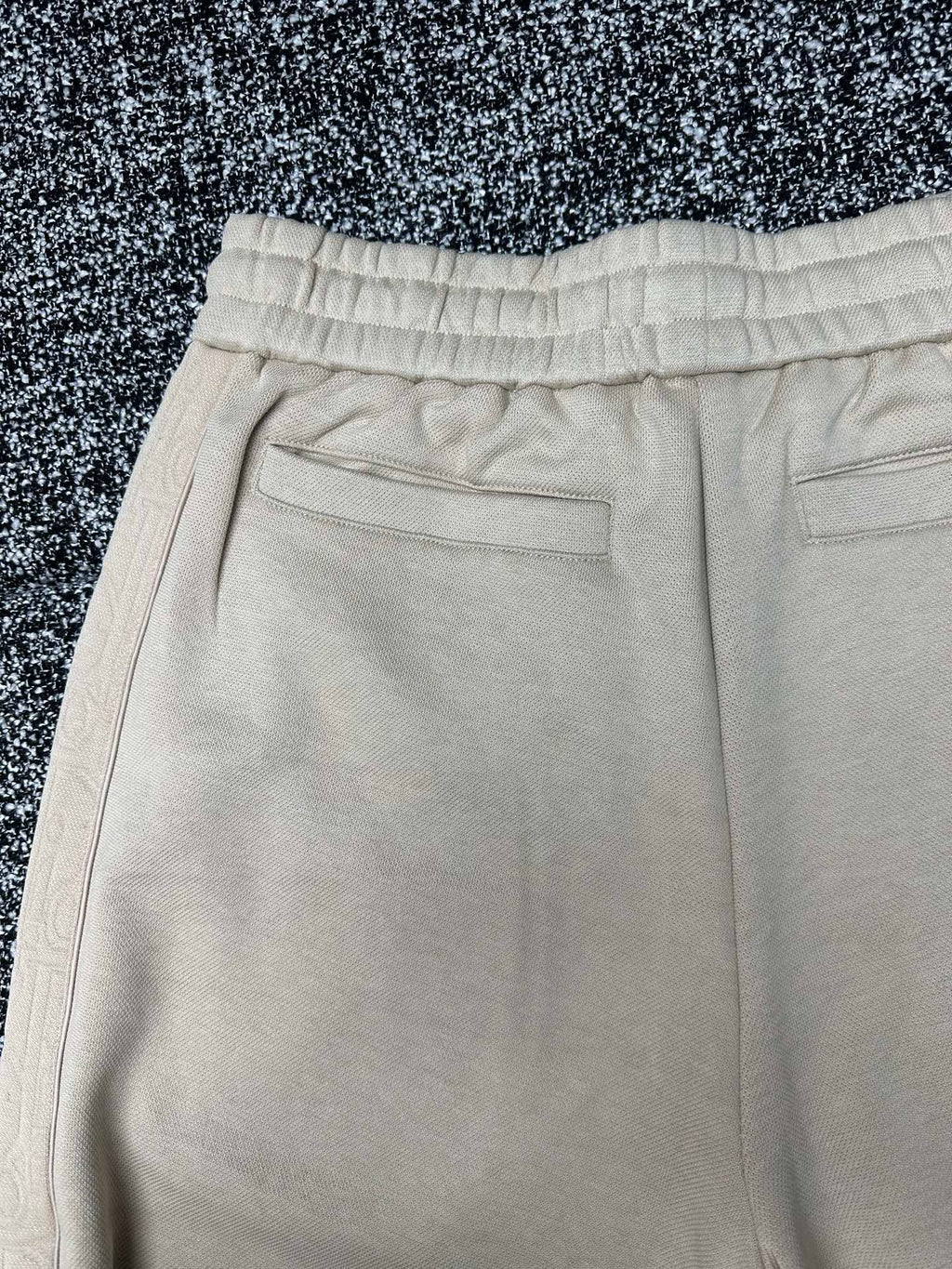 Cream pants close-up of front flap pockets and stitched waistband