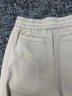 Cream pants close-up of front flap pockets and stitched waistband