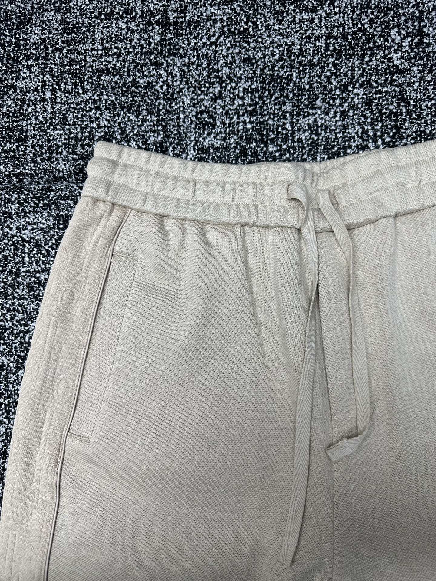 Cream drawstring pants with elastic waistband and flap pocket accents