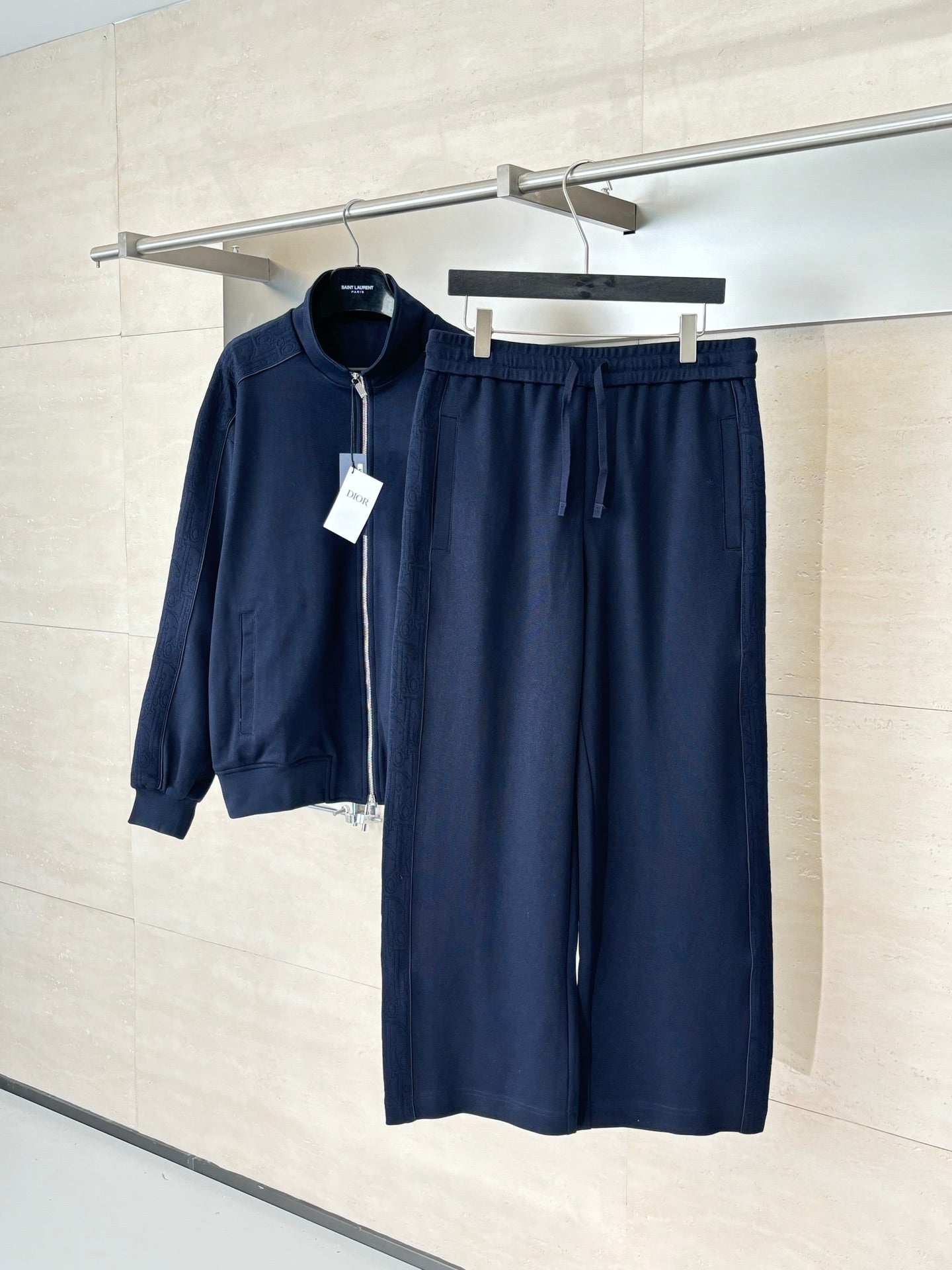 Navy wide-leg pants with drawstring waist, hung on a rack