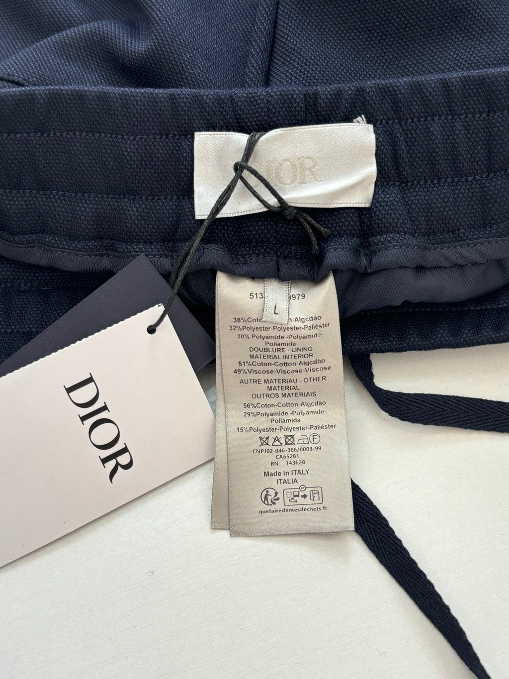 Navy pants with Dior brand label and care tag on elastic waist