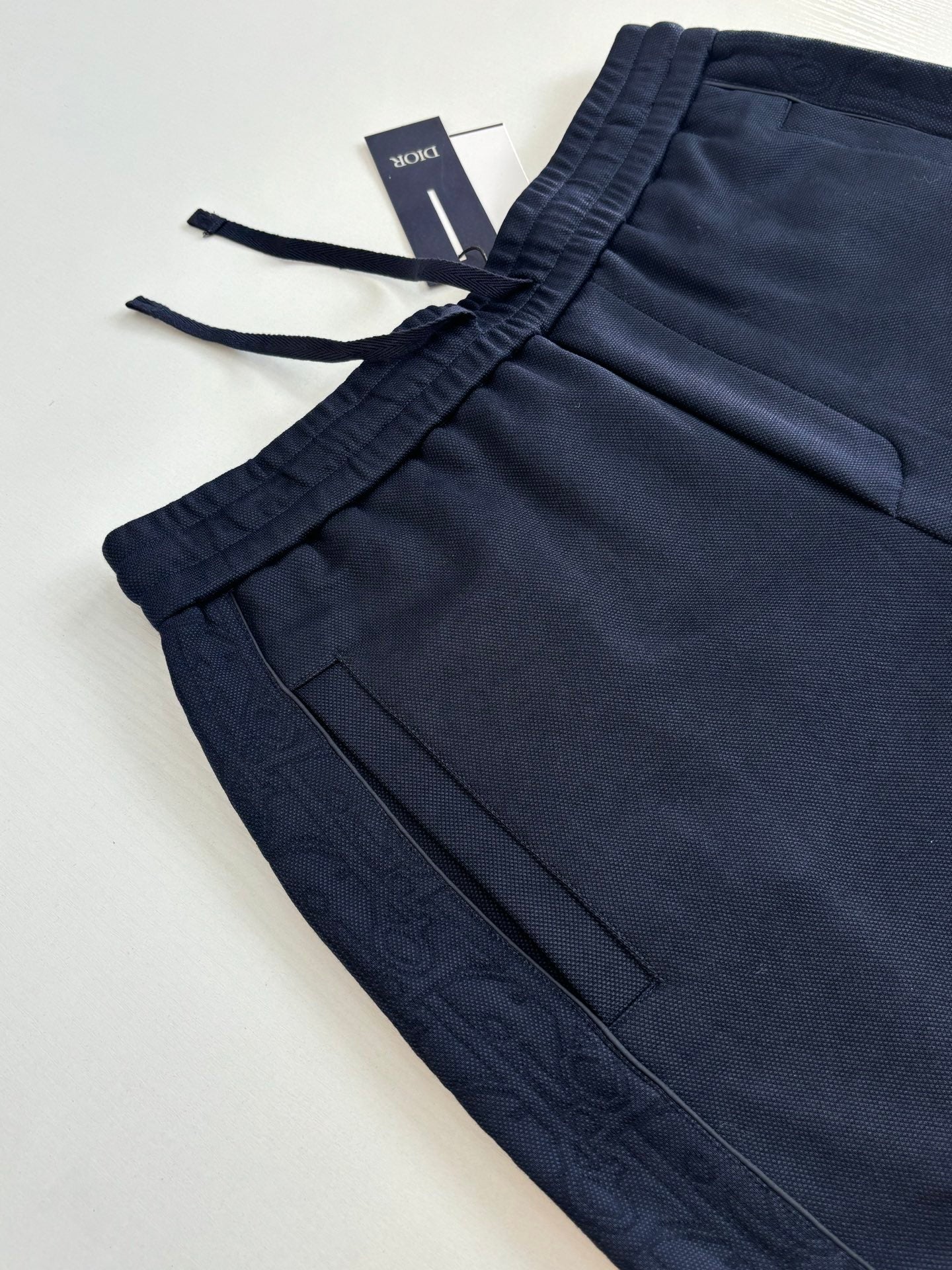 Navy pants with drawstring tie and front pocket seam lines