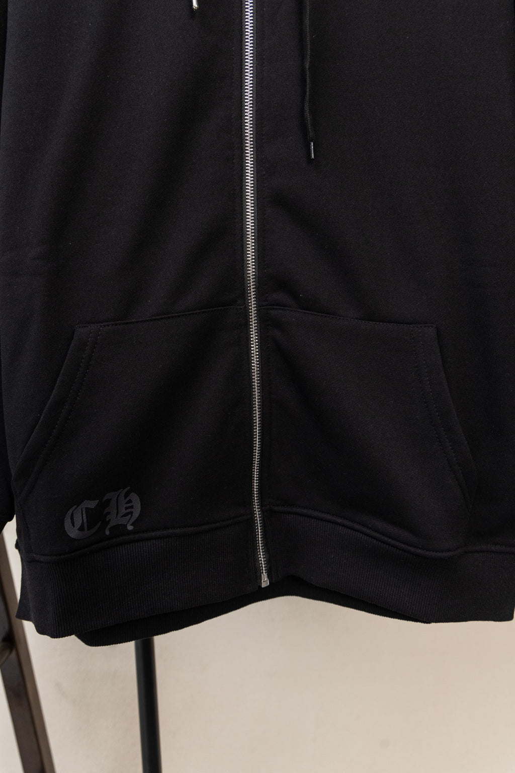 Black zip hoodie with kangaroo pocket and ribbed hem at the front