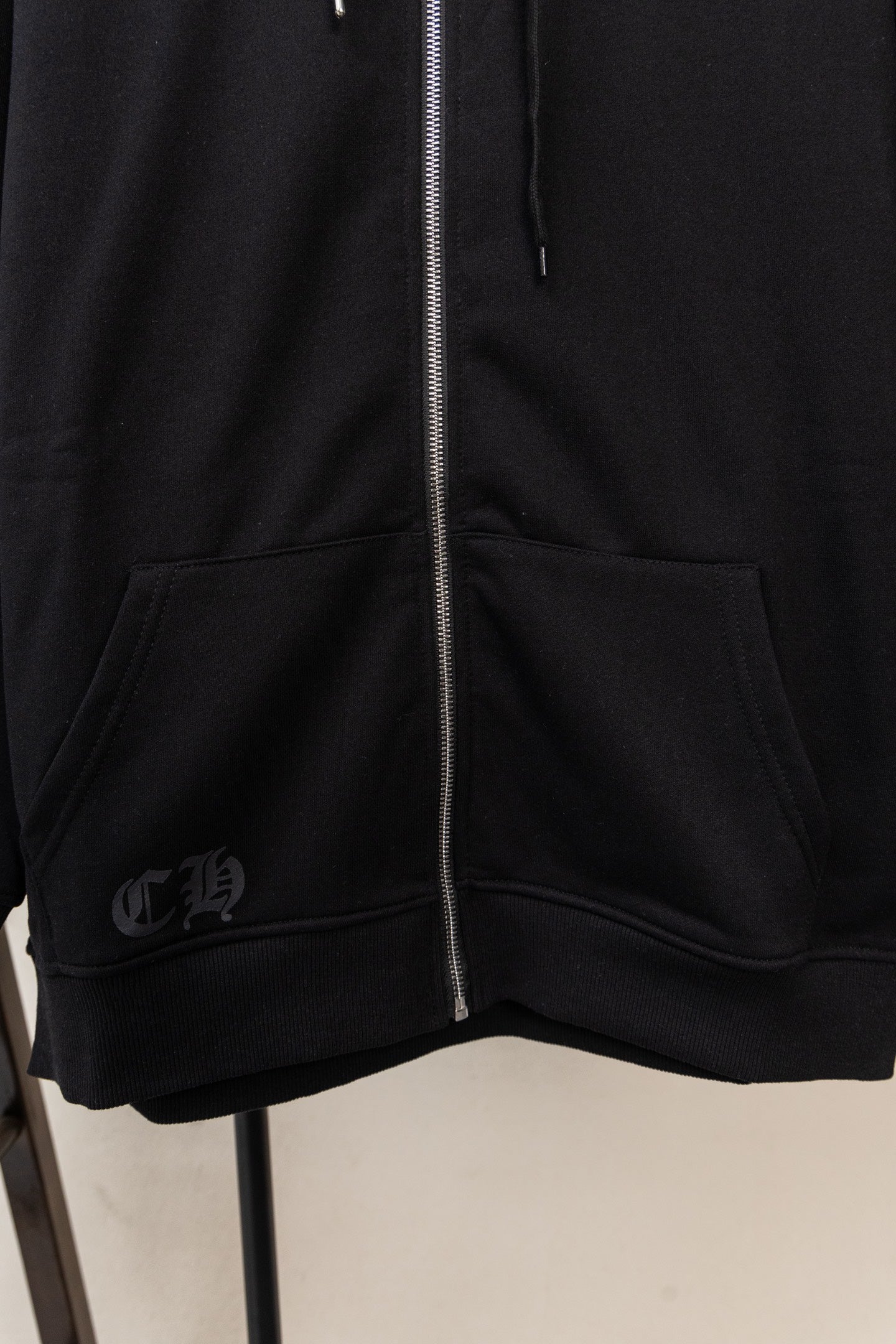 Black zip hoodie with kangaroo pocket and ribbed hem at the front