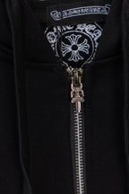 Black hoodie zipper and decorative emblem near the center placket