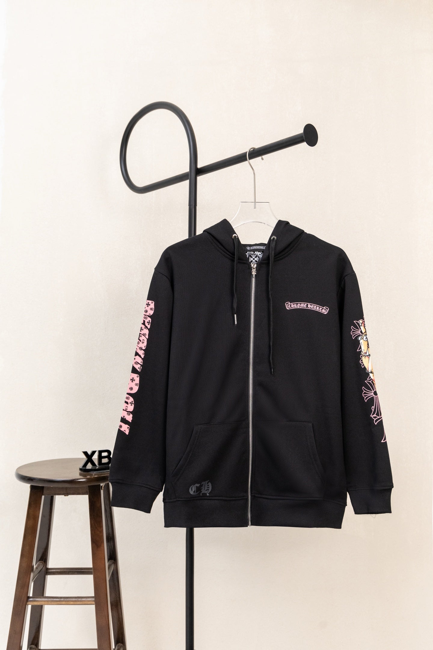 Black zip hoodie with pink floral graphic sleeves and front kangaroo pocket