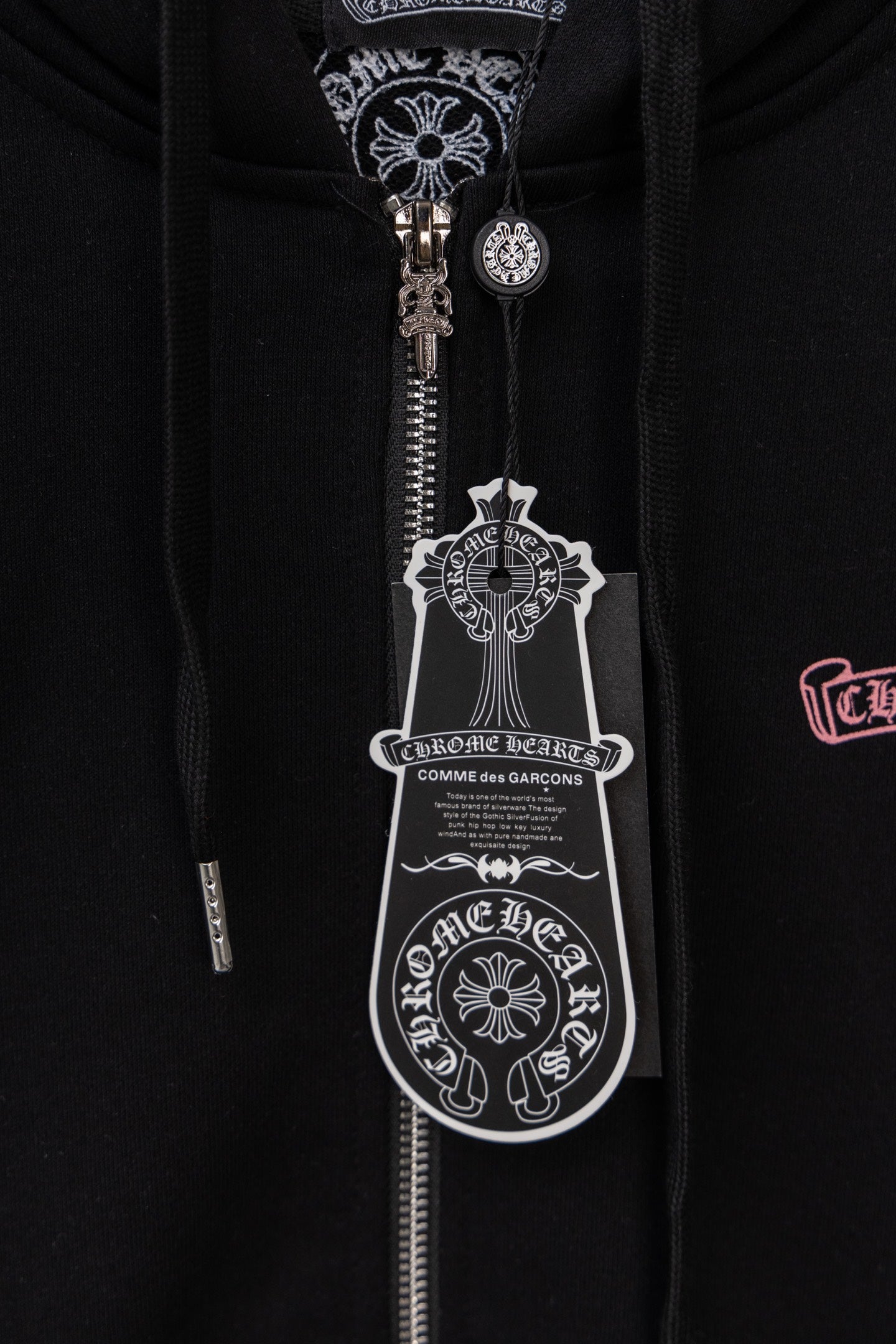 Black zip hoodie central zipper area with ornate graphic patch