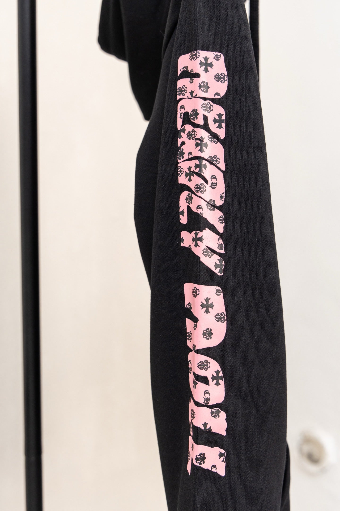 Black long-sleeve zip hoodie with pink graphic sleeve print