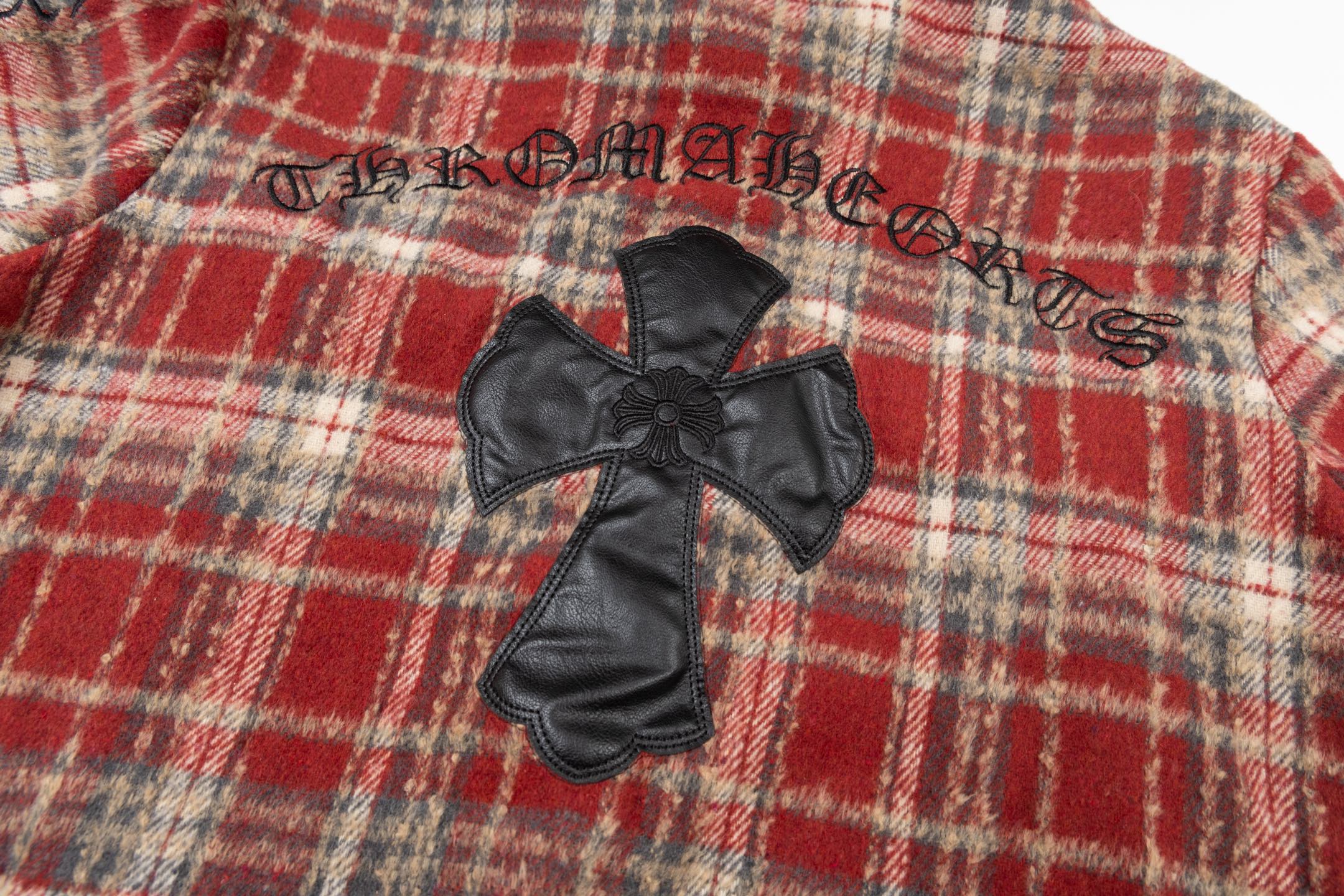 Red plaid shirt jacket with black cross applique detail on chest