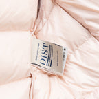 Light pink Moncler puffer jacket inner care label on fabric