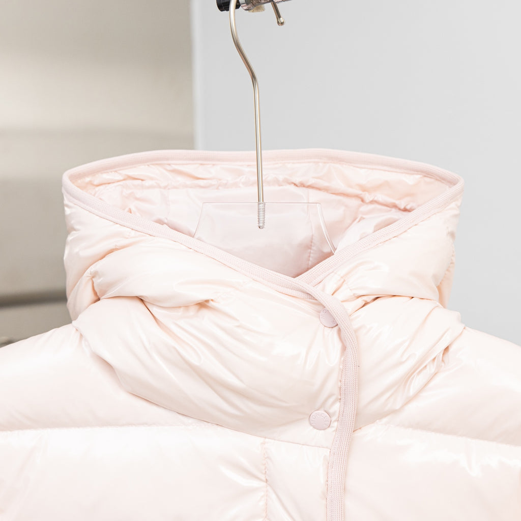 Light pink hooded puffer jacket with hood and buttoned front placket
