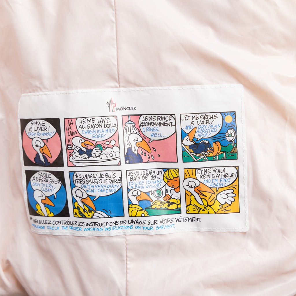 Light pink Moncler puffer jacket front panel with comic-style graphic instructions